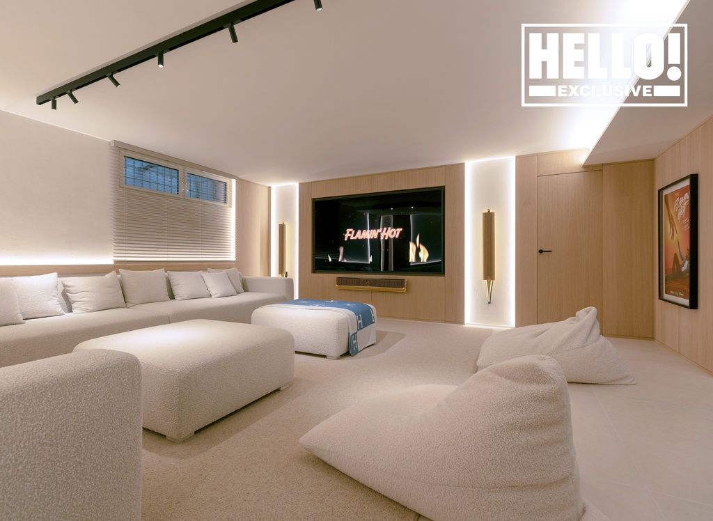 Eva Longoria living room with white beanbags and couches and giant TV 