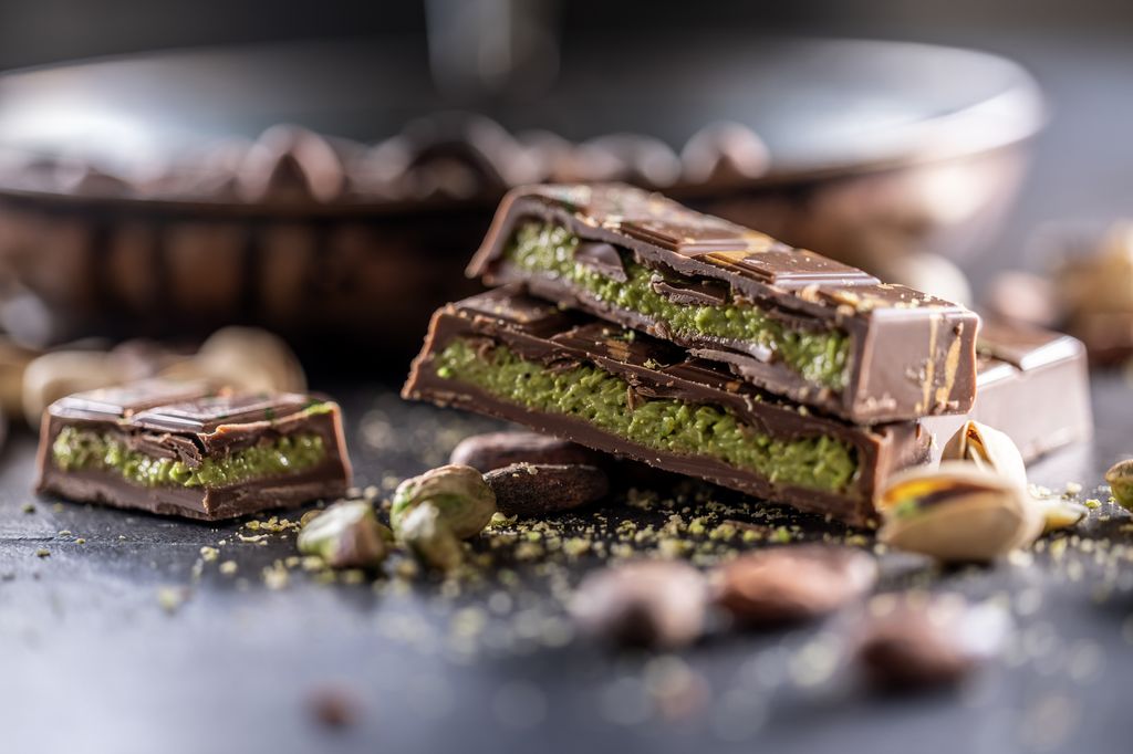 Dubai Chocolate bar with green kadayif and pistachio spread with pistachio nuts - close up 