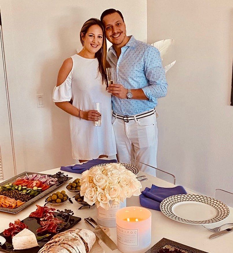 Princess Theodora in a white dress with her partner in front of a table of food