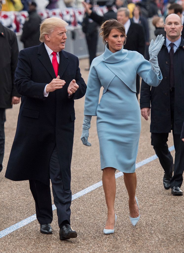 Melania Trump in blue Ralph Lauren dress walking with Donald Trump at the inauguration in 2017