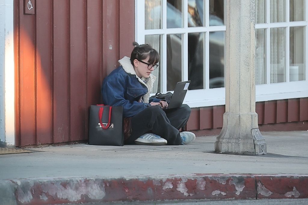 Fin sitting on the pavement with their laptop