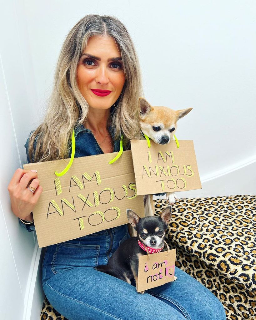 Blonde woman with her two dogs wearing signs about being anxious