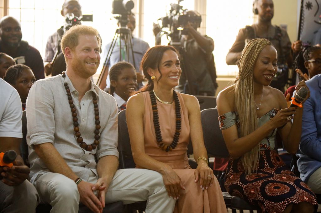 Prince Harry and Meghan Markle wearing traditional Nigerian necklaces