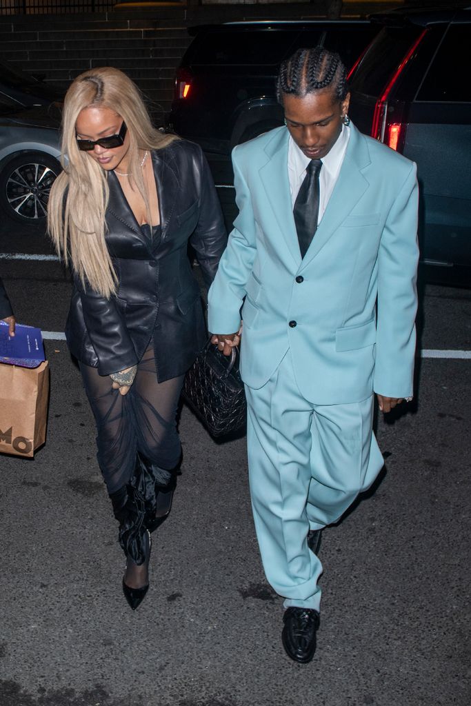Rihanna in black outfit and ASAP Rocky in blue suit walking 