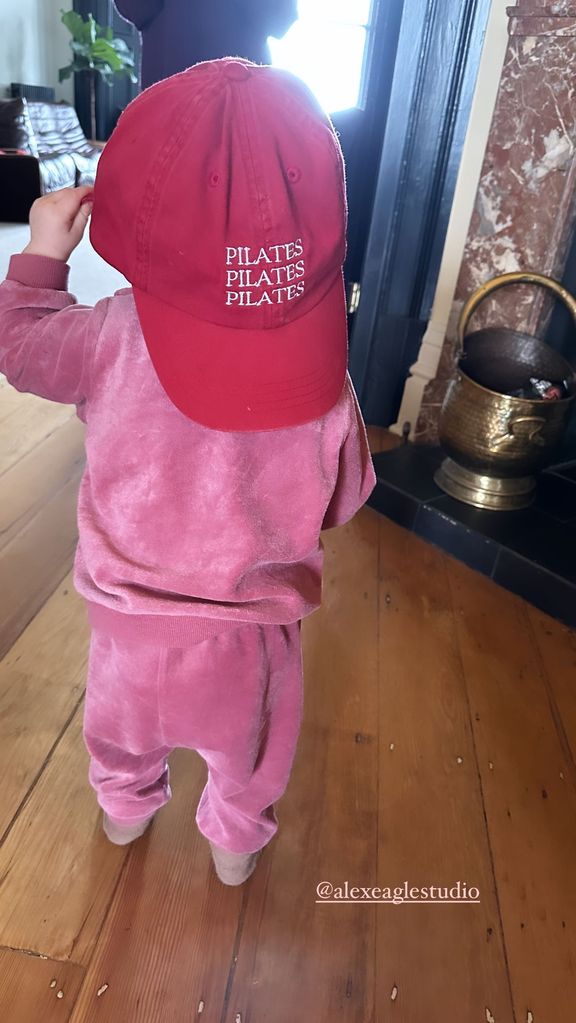 A photo fo Stacey Dooley's daughter Minnie wearing a pink tracksuit and red cap