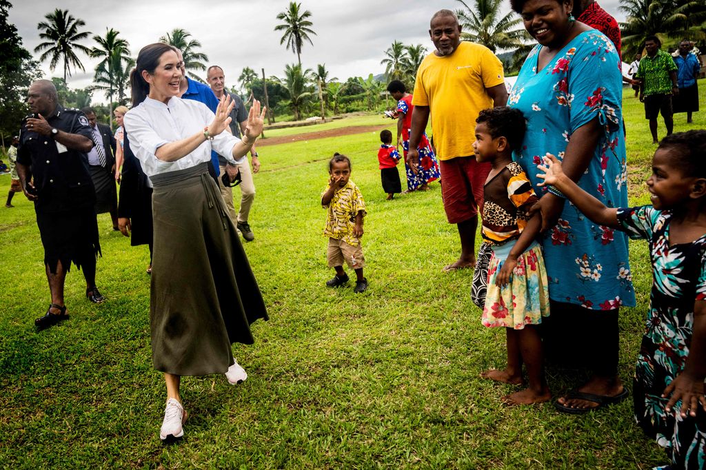 Crown Princess Mary of Denmark waves to residents during a visit to the local community at Nabavatu in Fiji
