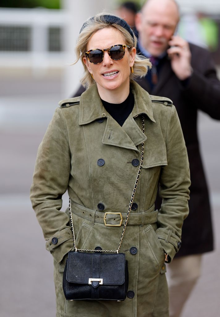 Zara in a khaki cinched coat and sunglasses