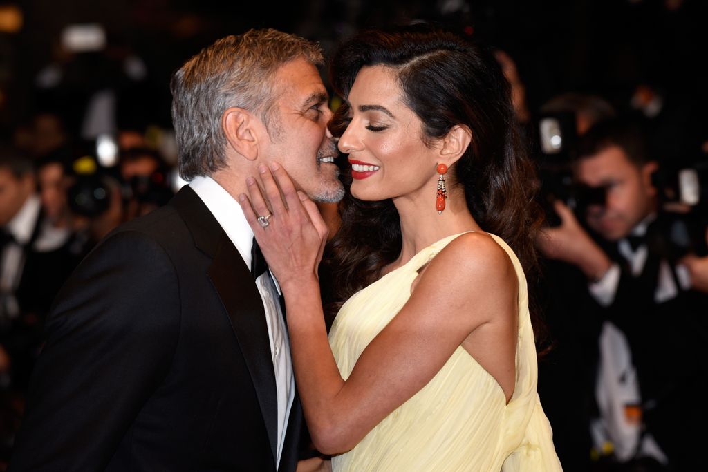 Amal Clooney holding George Clooney's face