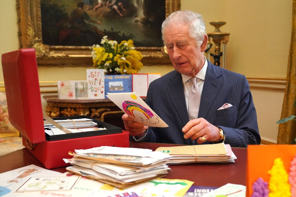 King Charles looking at card with rainbow