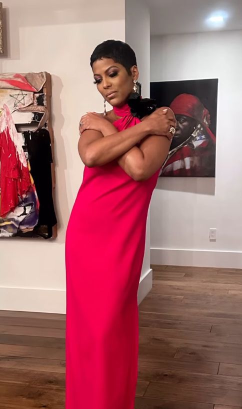 Tamron Hall with her arms over her body in a red dress