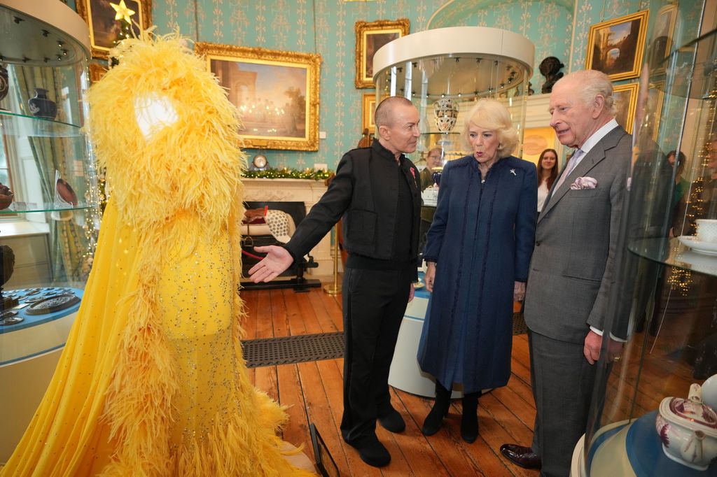 Charles and Camilla view a fashion design as they join a celebratory reception marking Cyfarthfa Castle's 200th anniversary 