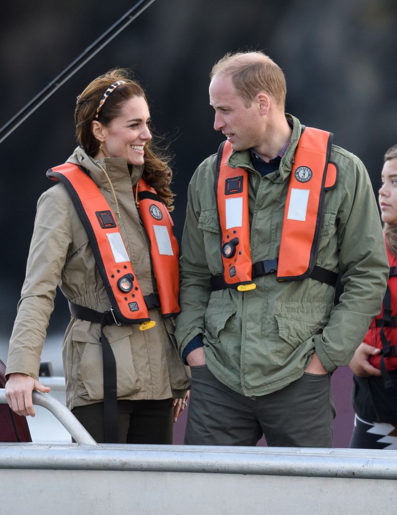 couple on fishing boat in life jackets 