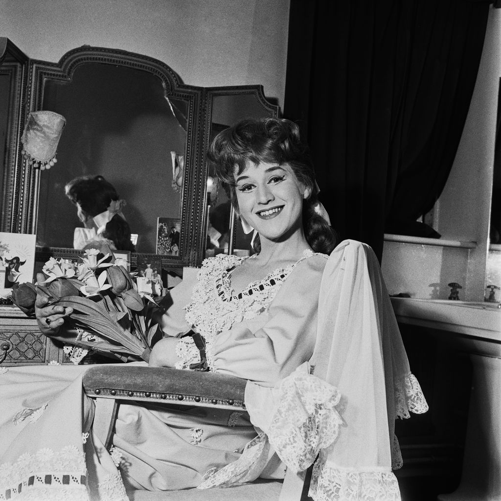 Patricia Routledge sitting in her dressing room with a bouquet of flowers