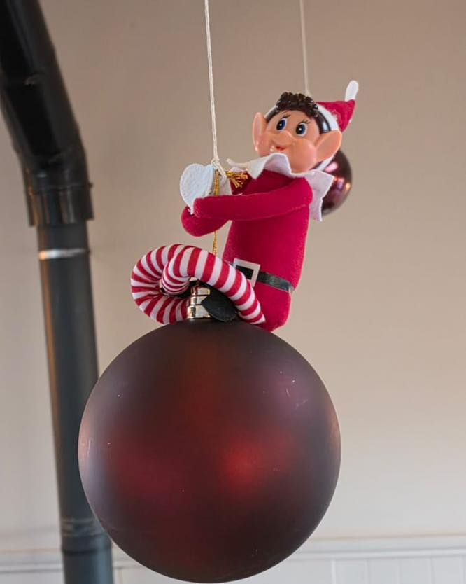 elf on the shelf  swinging on a bauble