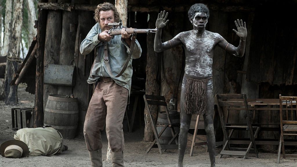 Simon Baker pointing a gun at Jacob Junior Nayinggul in a scene from High Ground