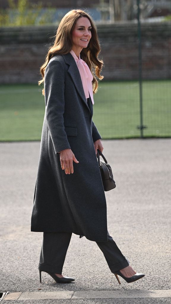 Kate in school playground in soft pink blouse and grey coat