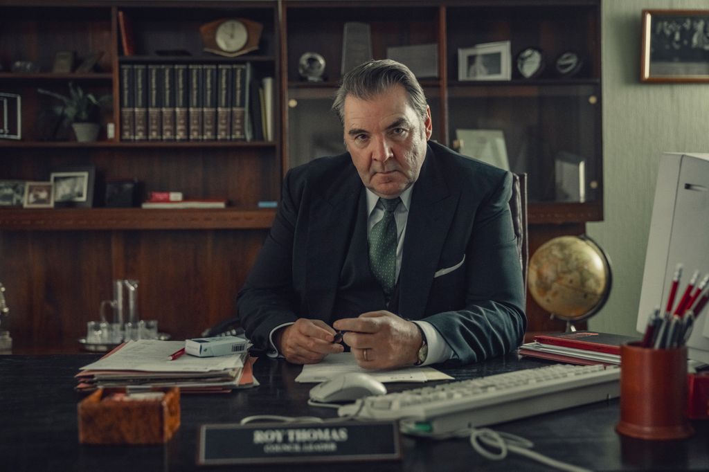 Man in suit sitting behind desk in office