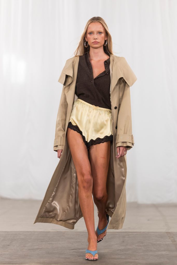 model walks in trench coat for Rotate SS26
