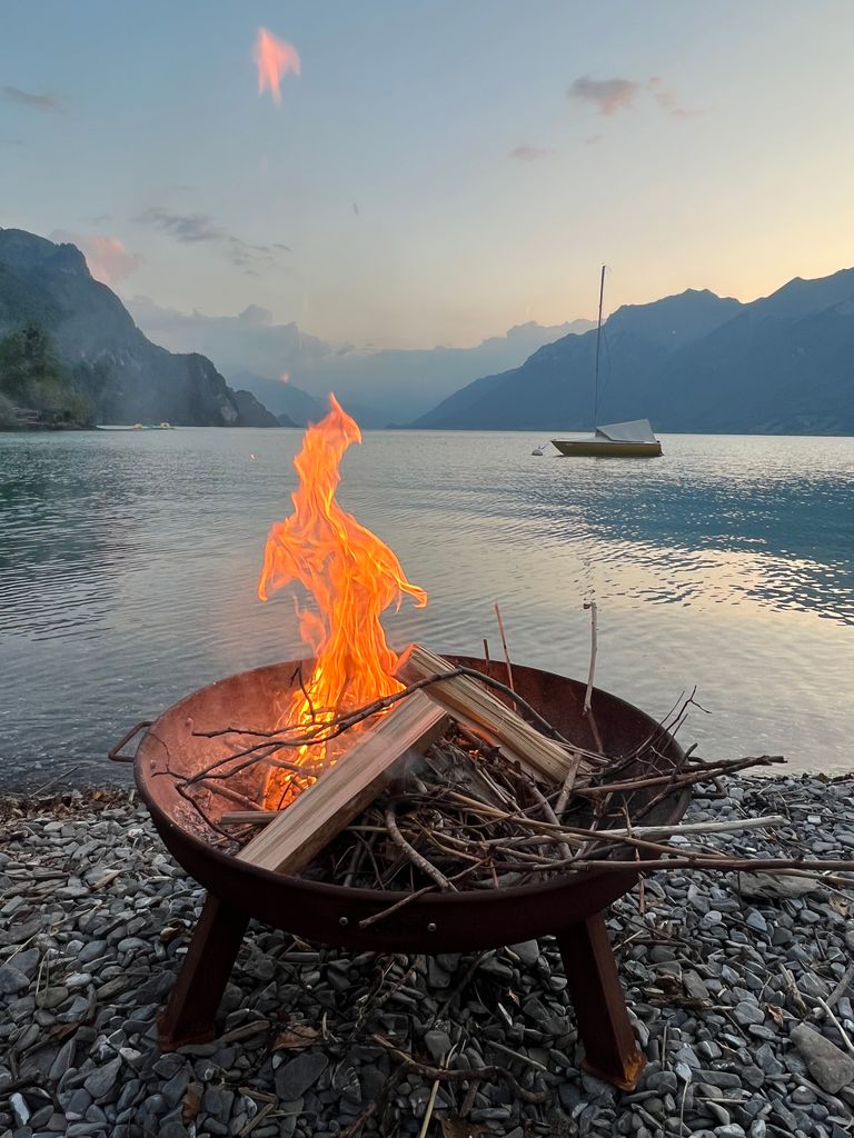 camp fire in front of a lake 