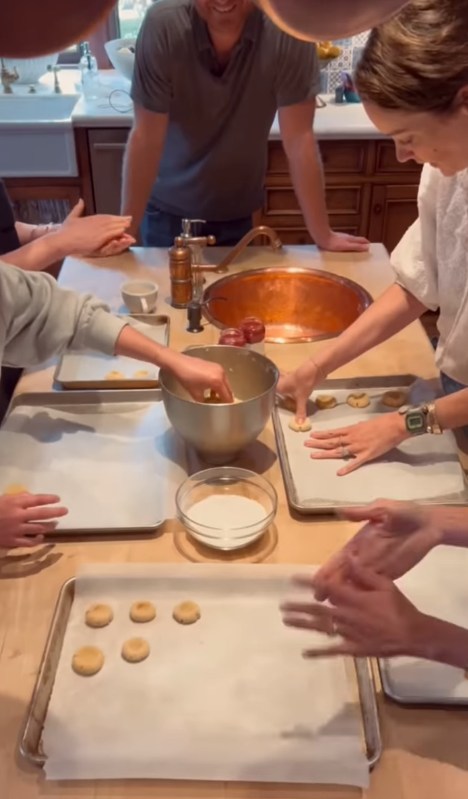 Meghan and friends gather around her kitchen island while baking cookies
