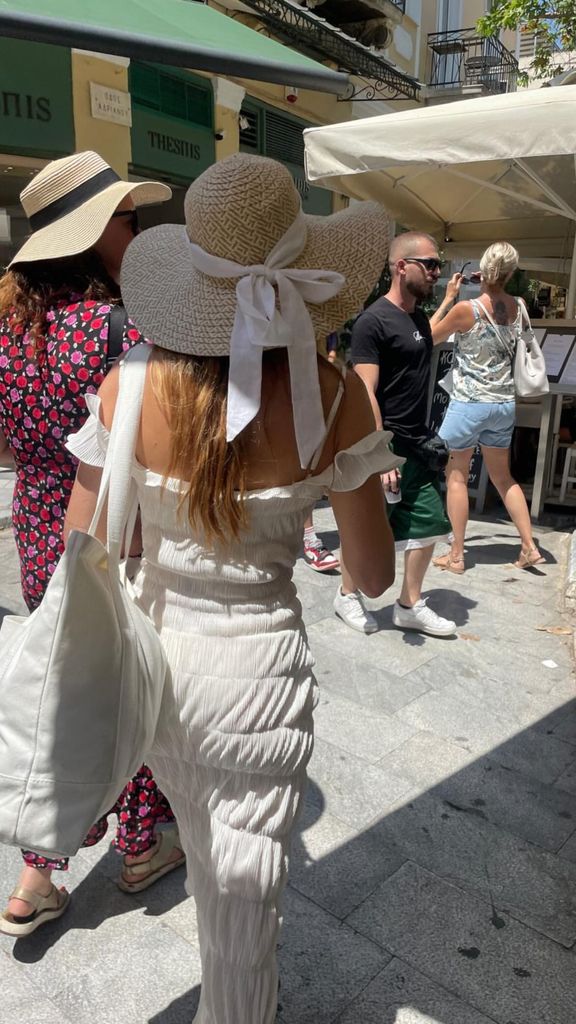 Faye Harris in a white dress and sun hat