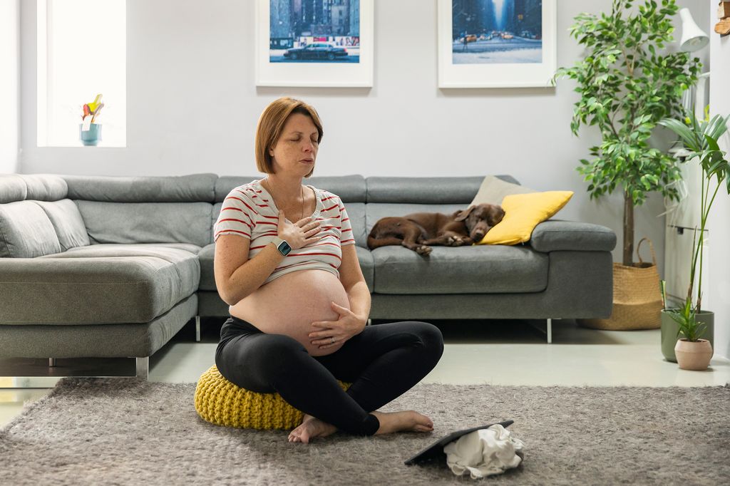 pregnant woman practising breathing exercises at home
