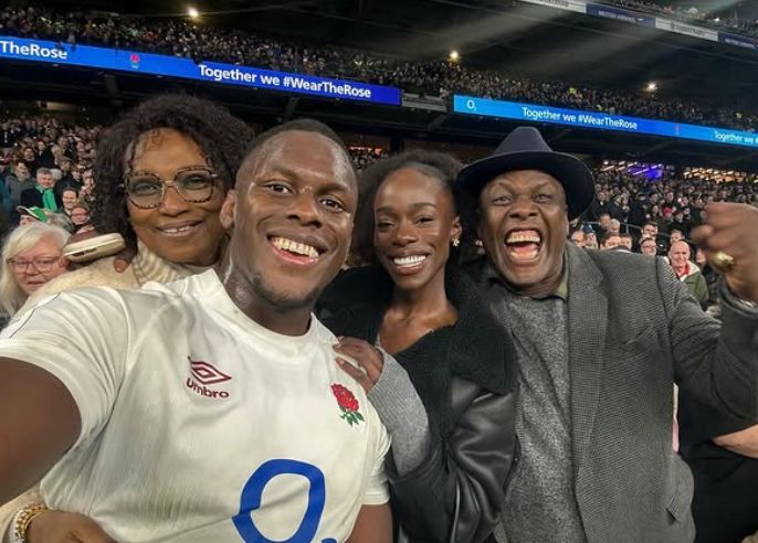 Maro Itoje and Mimi Fall with two people celebrating at a rugby match