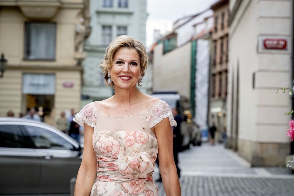 Queen Maxima smiling in a floral dress