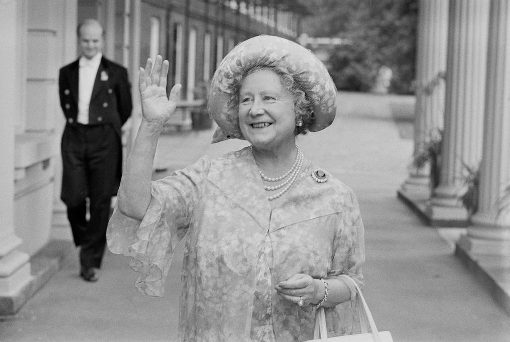 A black-and-white photo of the Queen Mother waving