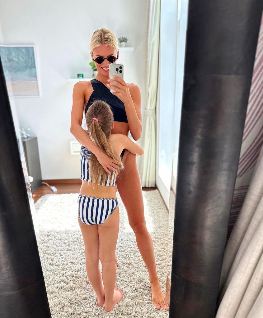 Nadiya Bychkova in a black bikini hugging her daughter
