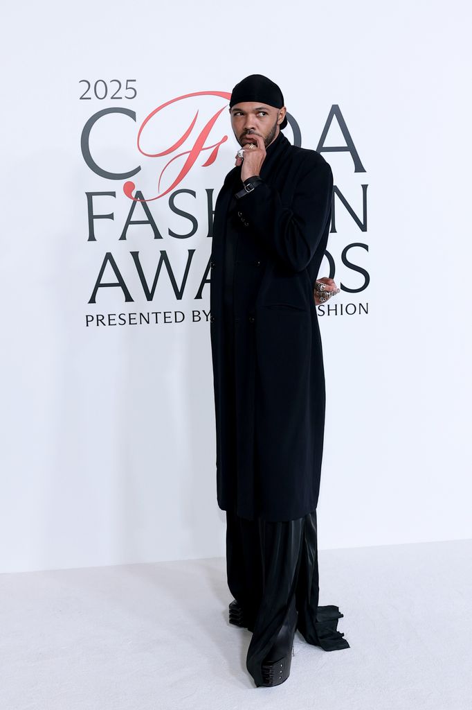 Kyle Smith at the 2025 CFDAs posing on the red carpet in a black ensemble head to toe