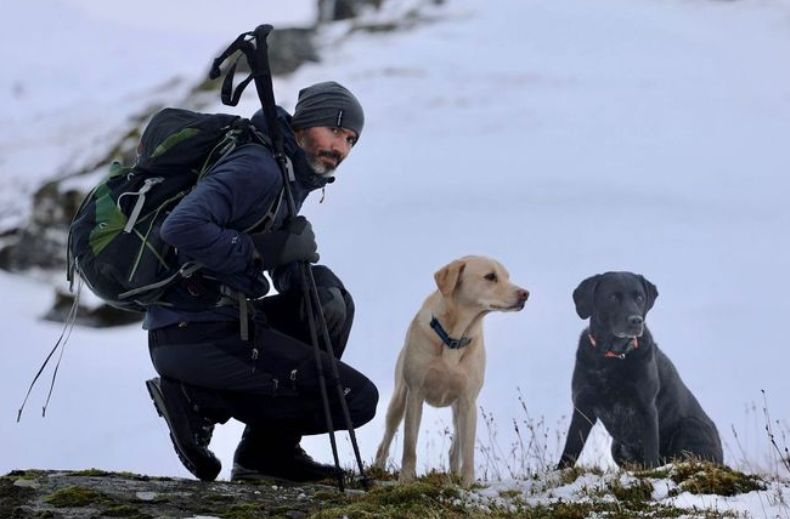 Andrew Cotter and two dogs on a mountain