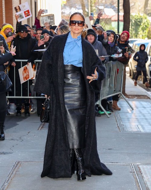 JLo's in chic leather skirt, black coat and blue shirt