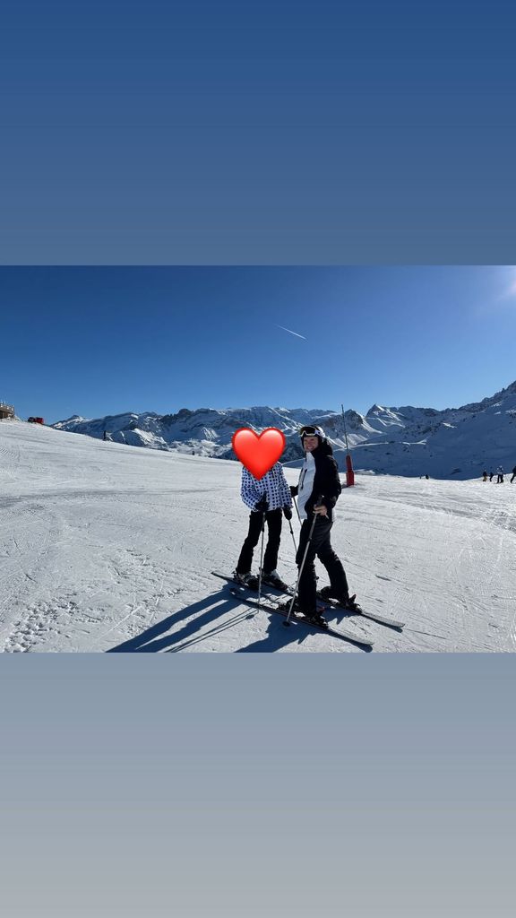 Two people posing on the ski slopes 