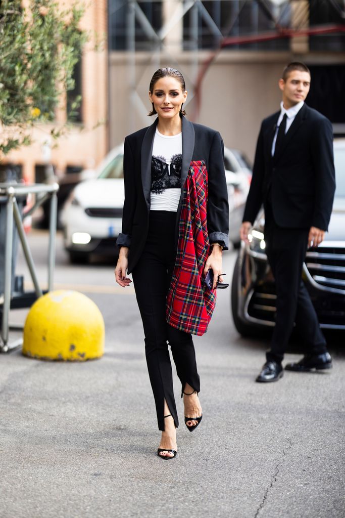 MILAN, ITALY - SEPTEMBER 20: Olivia Palermo is seen wearing black, shiny leather heels, black high-waist trousers, a white t-shirt, a black lace bra and a black oversized blazer with a red tartan-print detail outside the Antonio Marras show during the Milan Fashion Week Womenswear Spring/Summer 2024 on September 20, 2023 in Milan, Italy. (Photo by Valentina Frugiuele/Getty Images)
