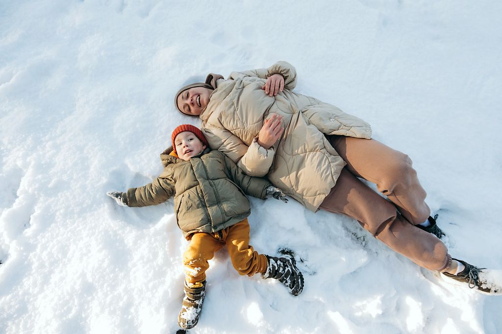 Une mère et son jeune fils allongé dans la neige