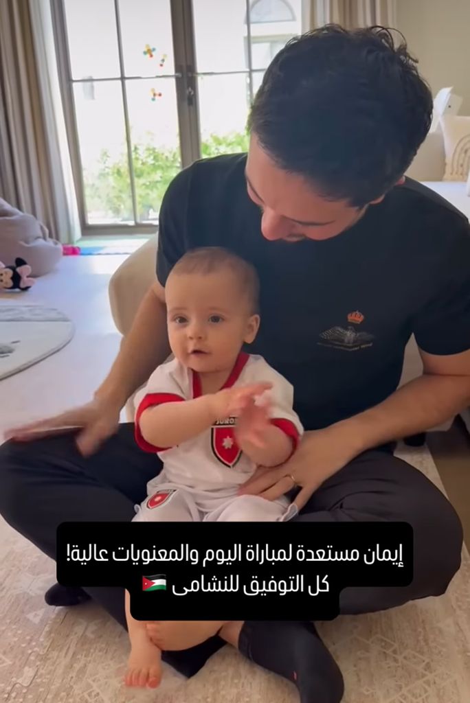 Crown Prince Hussein holding baby Princess Iman in Jordan football kit