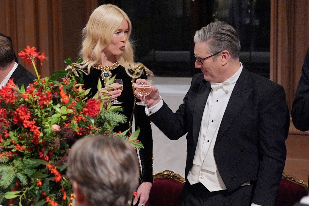 Guests, including German model Claudia Schiffer (L) and Britain's Prime Minister Keir Starmer (R), raise a toast during the state banquet 