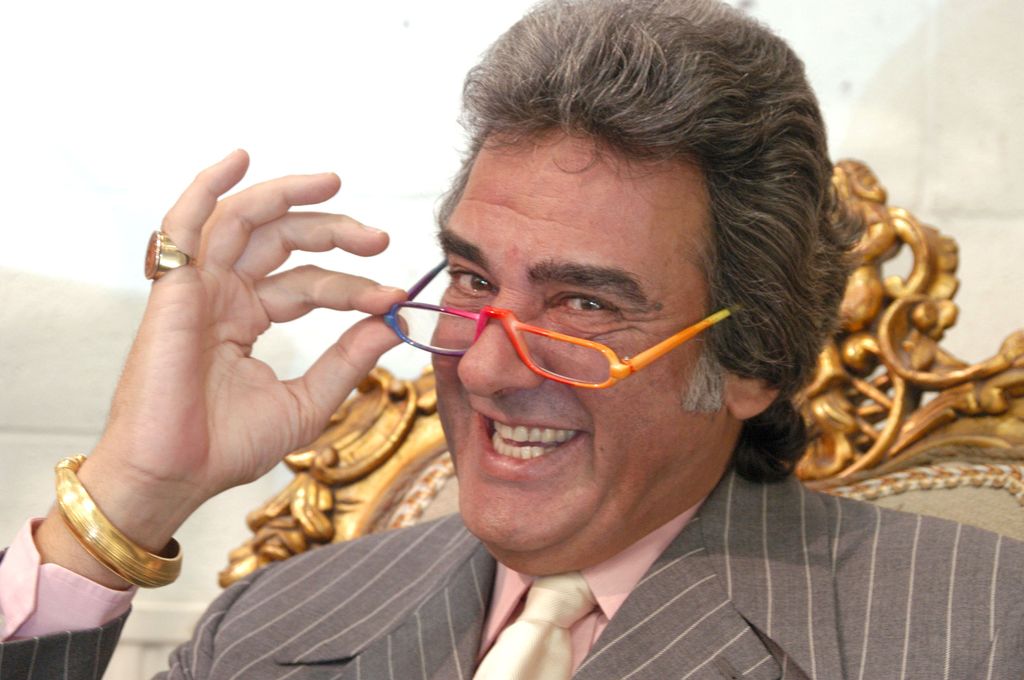 Man with orange glasses smiling at camera
