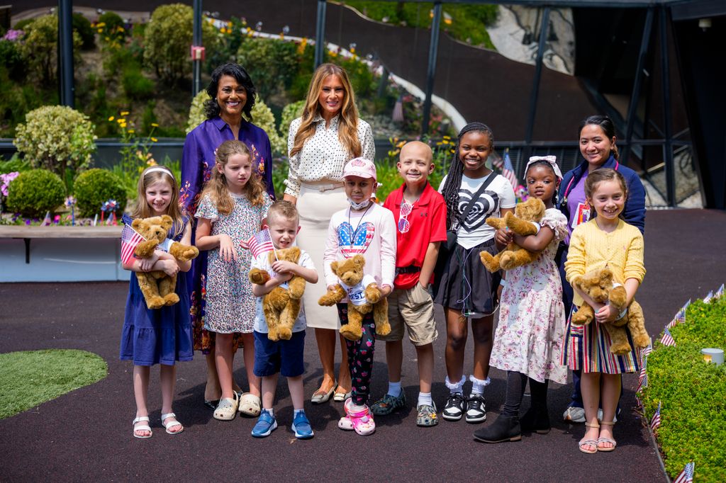 Melania Trump, accompagnée de la présidente et chef de la direction de l'hôpital national des enfants, Michelle Riley-Brown (L), pose pour une photo avec des enfants dans le jardin de guérison du lapin Mellon à l'hôpital national pour enfants