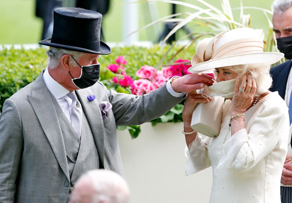 Charles helps Camilla put on her face mask as they attend day 2 of Royal Ascot in 2021