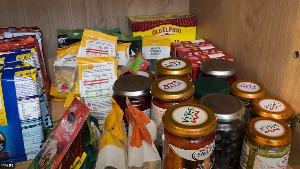 Davina McCall's kitchen cupboard with pesto jars and nuts and snacks 