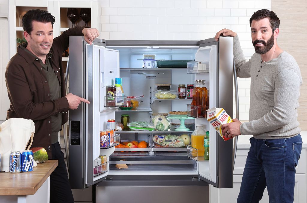 The brothers standing alongside a Whirlpool fridge