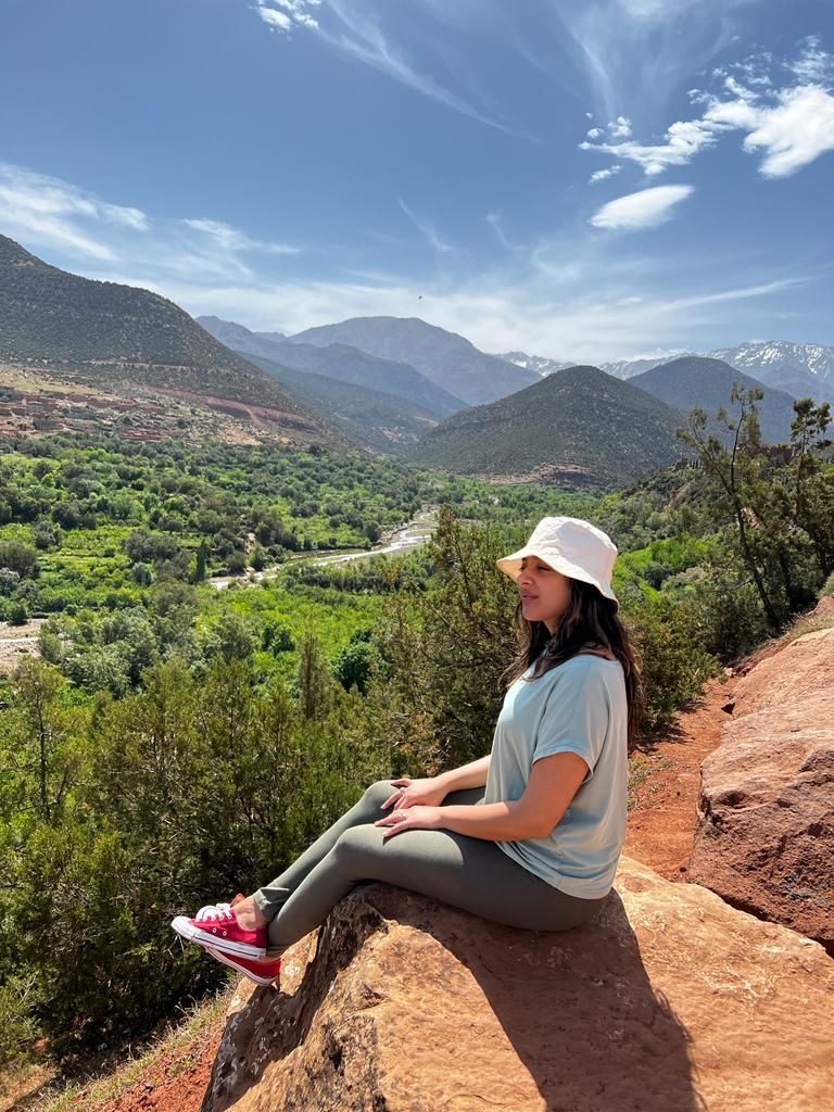 young woman in a white hat looking out over scenery