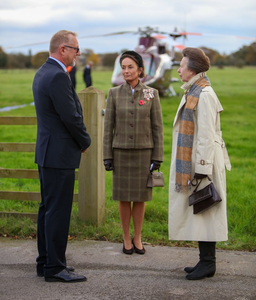 Princesa Anne complementada com um lenço do Rei e uma bolsa preta envernizada