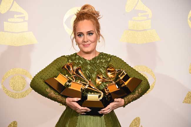 Adele clutching her awards