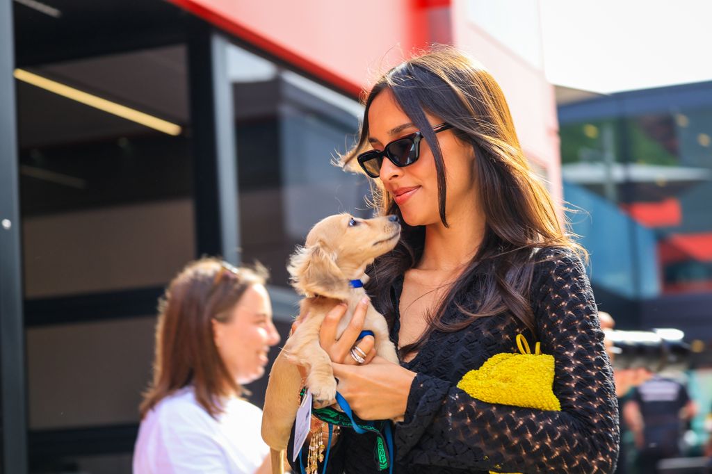 Alexandra Saint Mleux carrying a small puppy