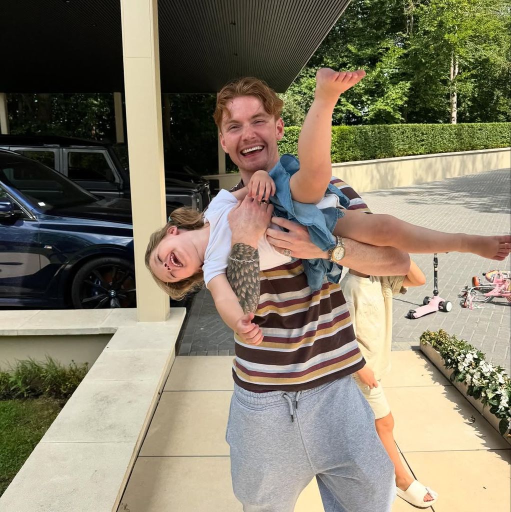 Jack Keating lifting his daughter Maya in the air