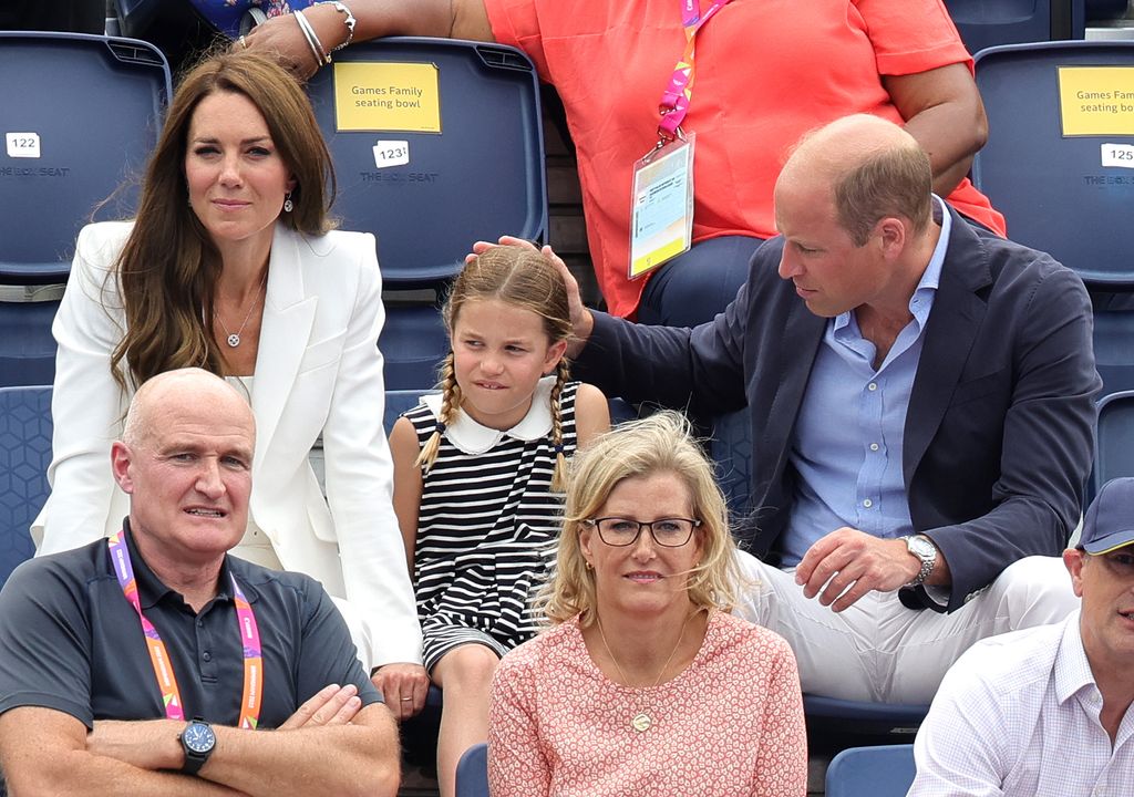William with hand resting on charlotte's head sitting in stands