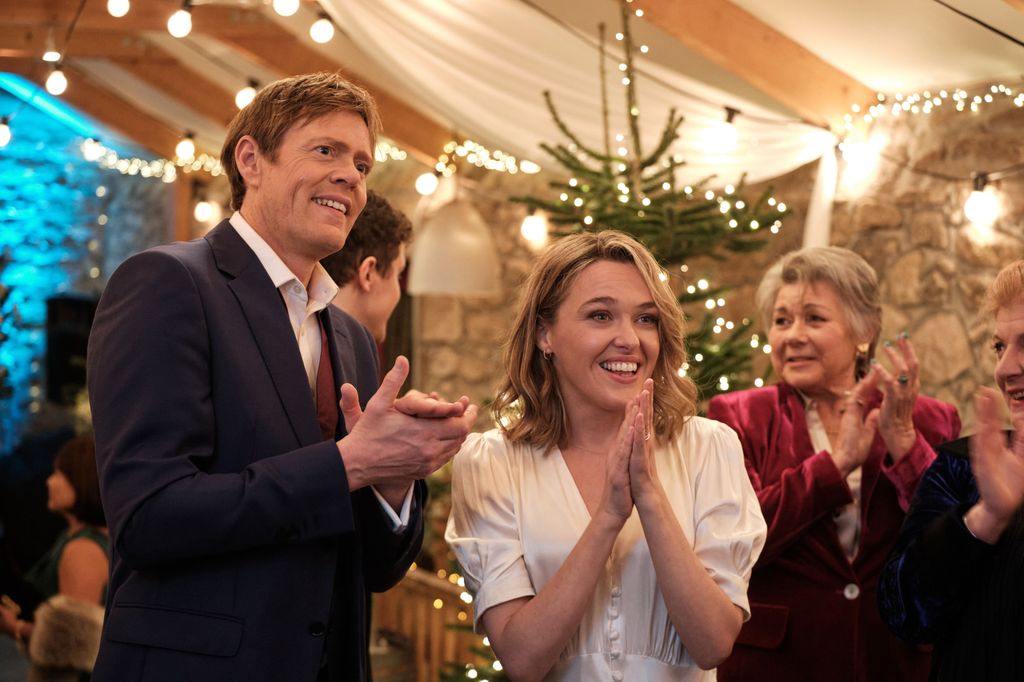 man and woman in room filled with fairy lights